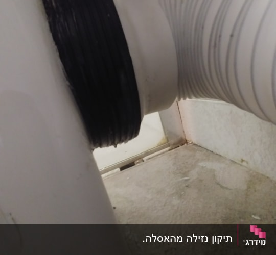 צינור פלסטיק מחובר לאסלה עם אטם שחור
